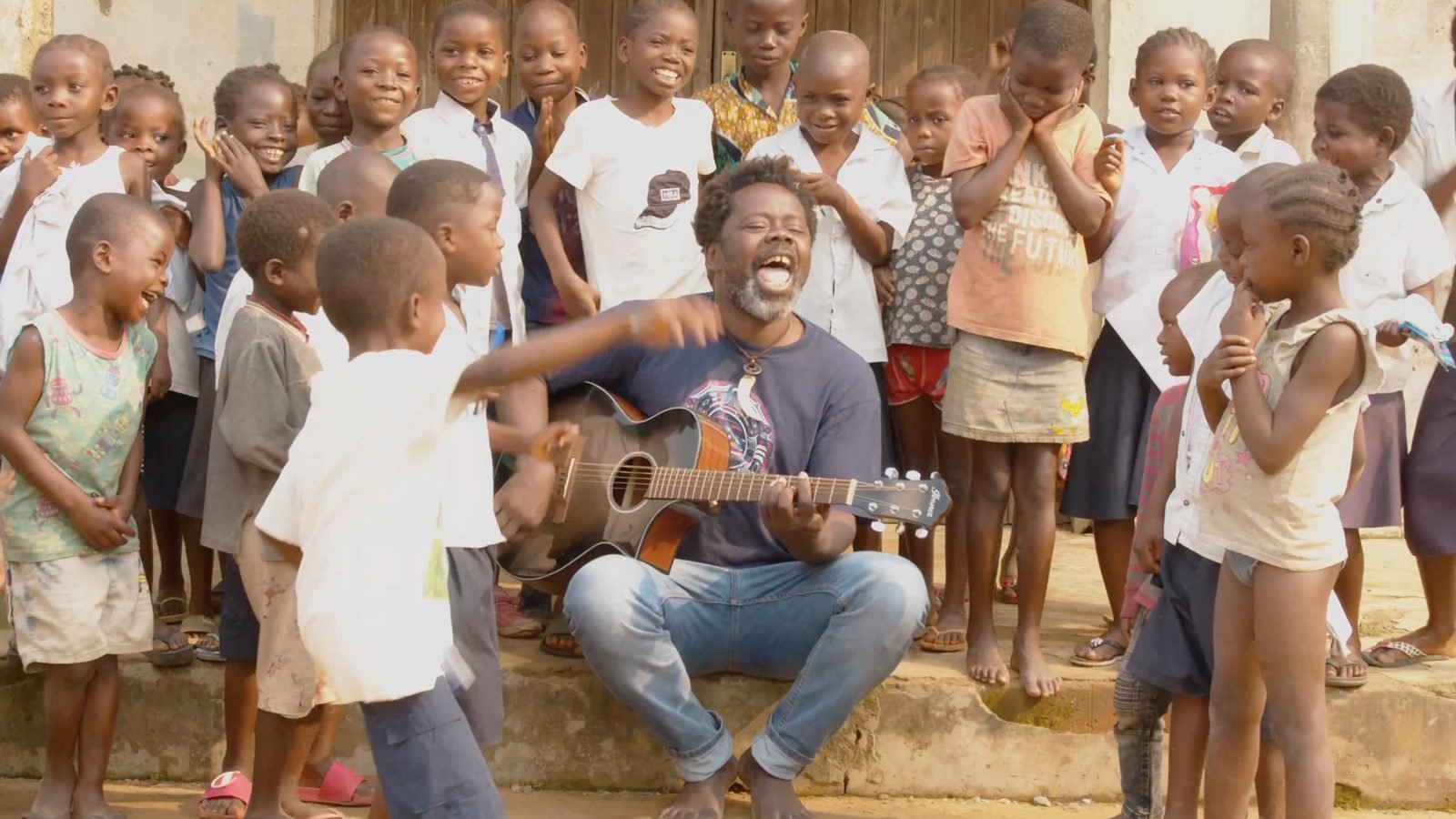 Mermans playing guitar surrounded by children
