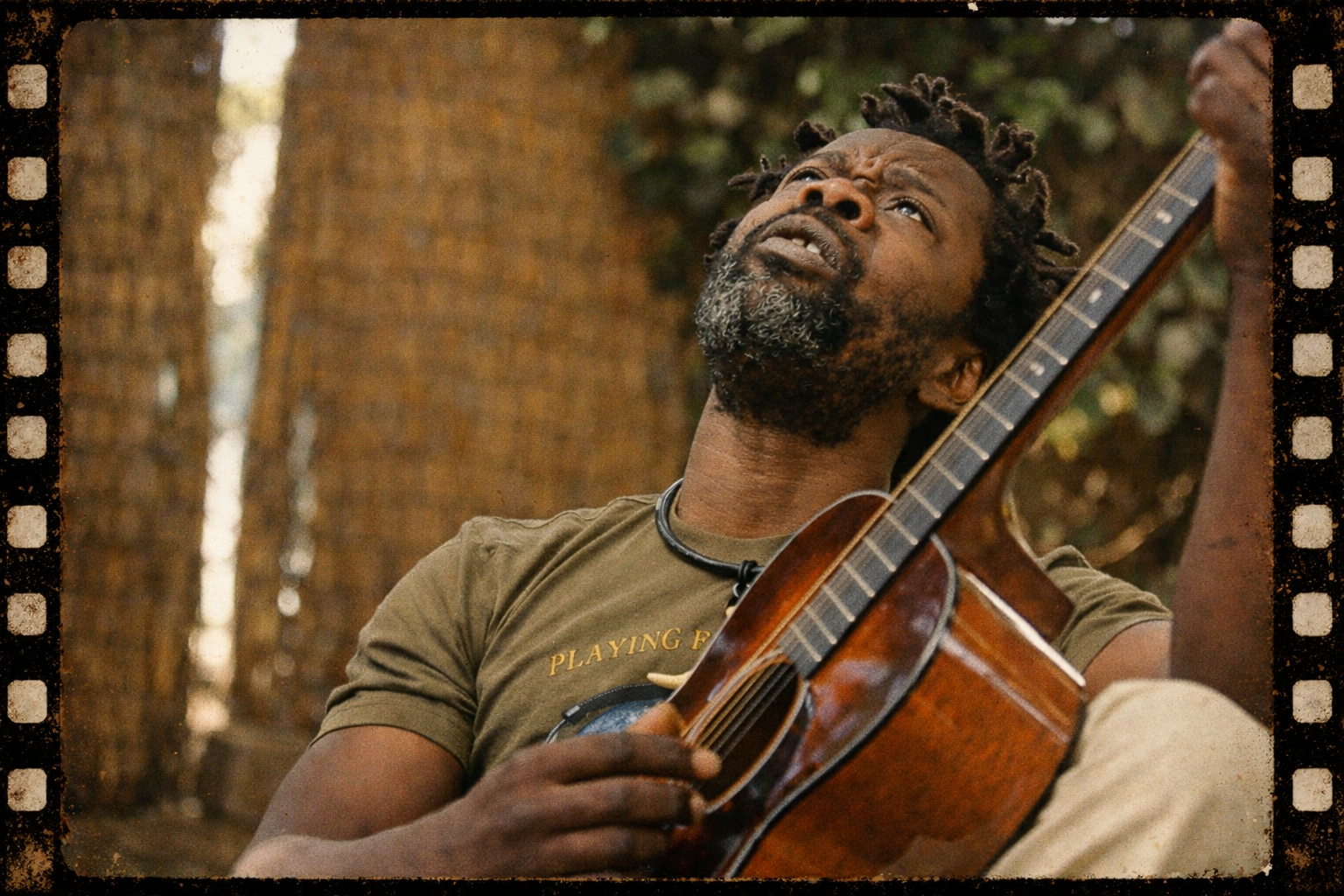 Mofaya playing guitar looking skyward