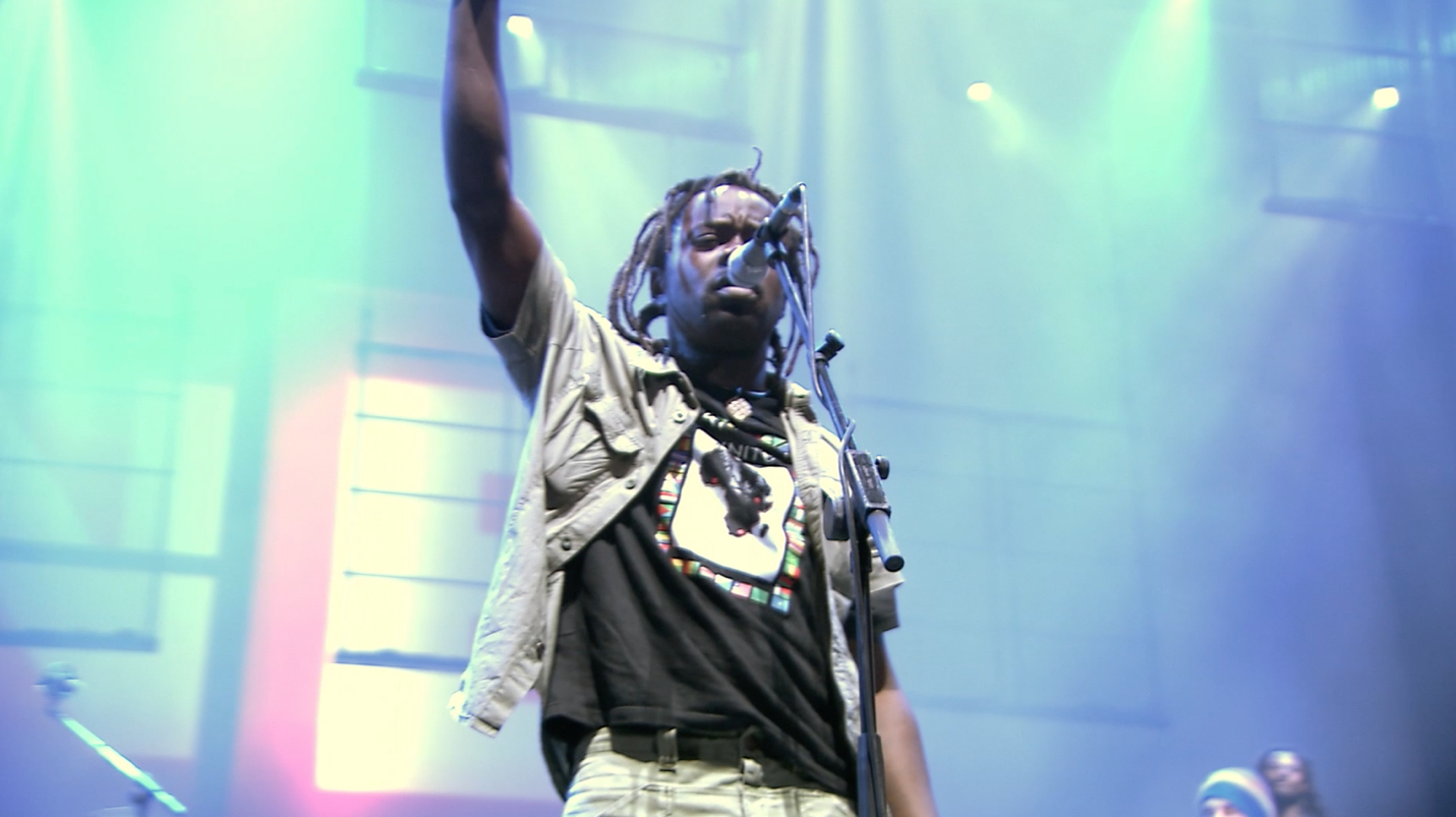 Mermans performing on stage with arm raised